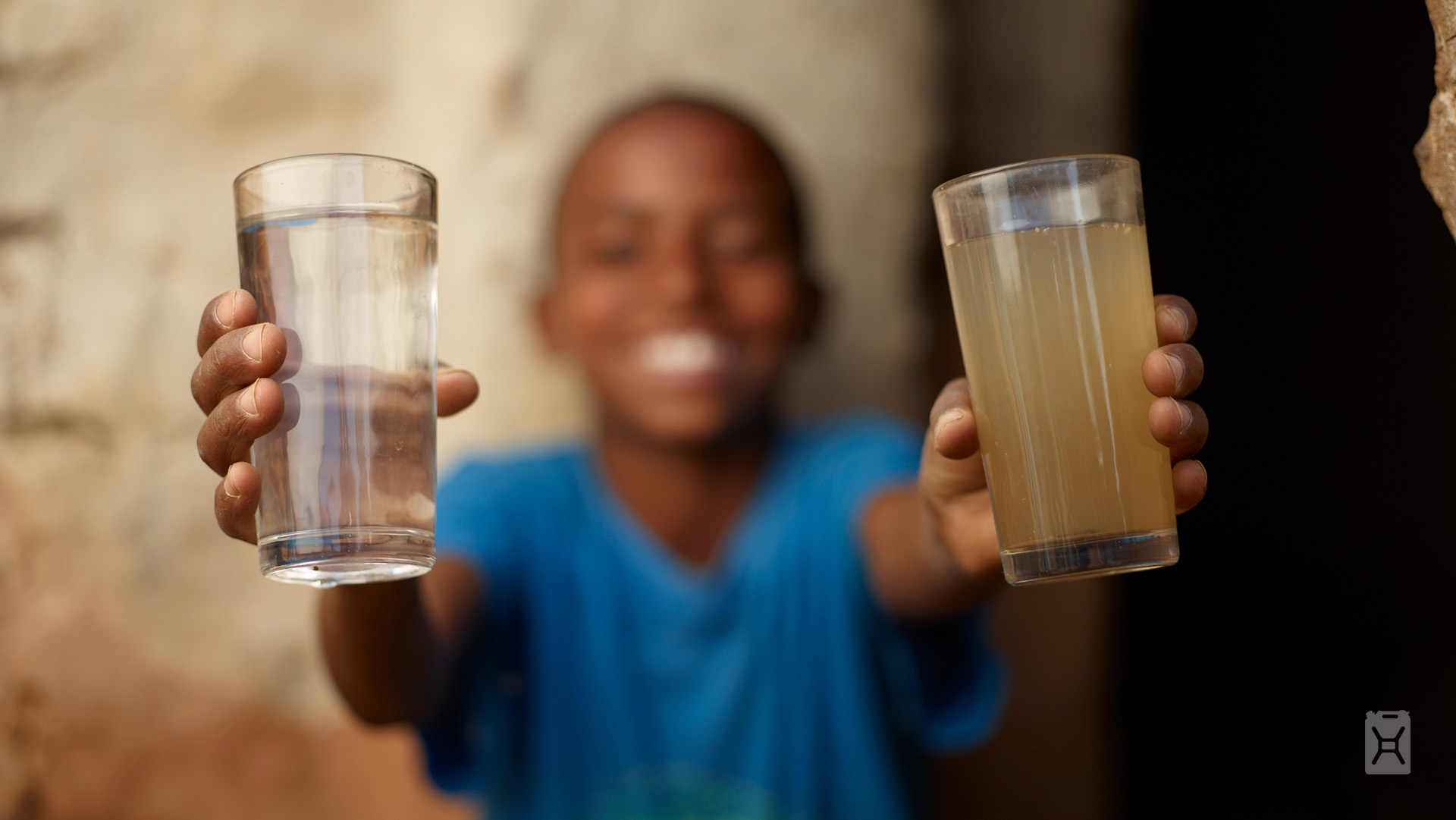 A photo of a boy comparing clean and dirty drinking water